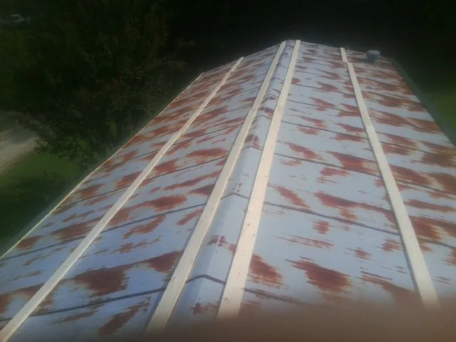 Rusted metal roof panels with new wood purlins before replacement — Storm Damage Roof Repair in Buzzards Bay by Roofing Brothers