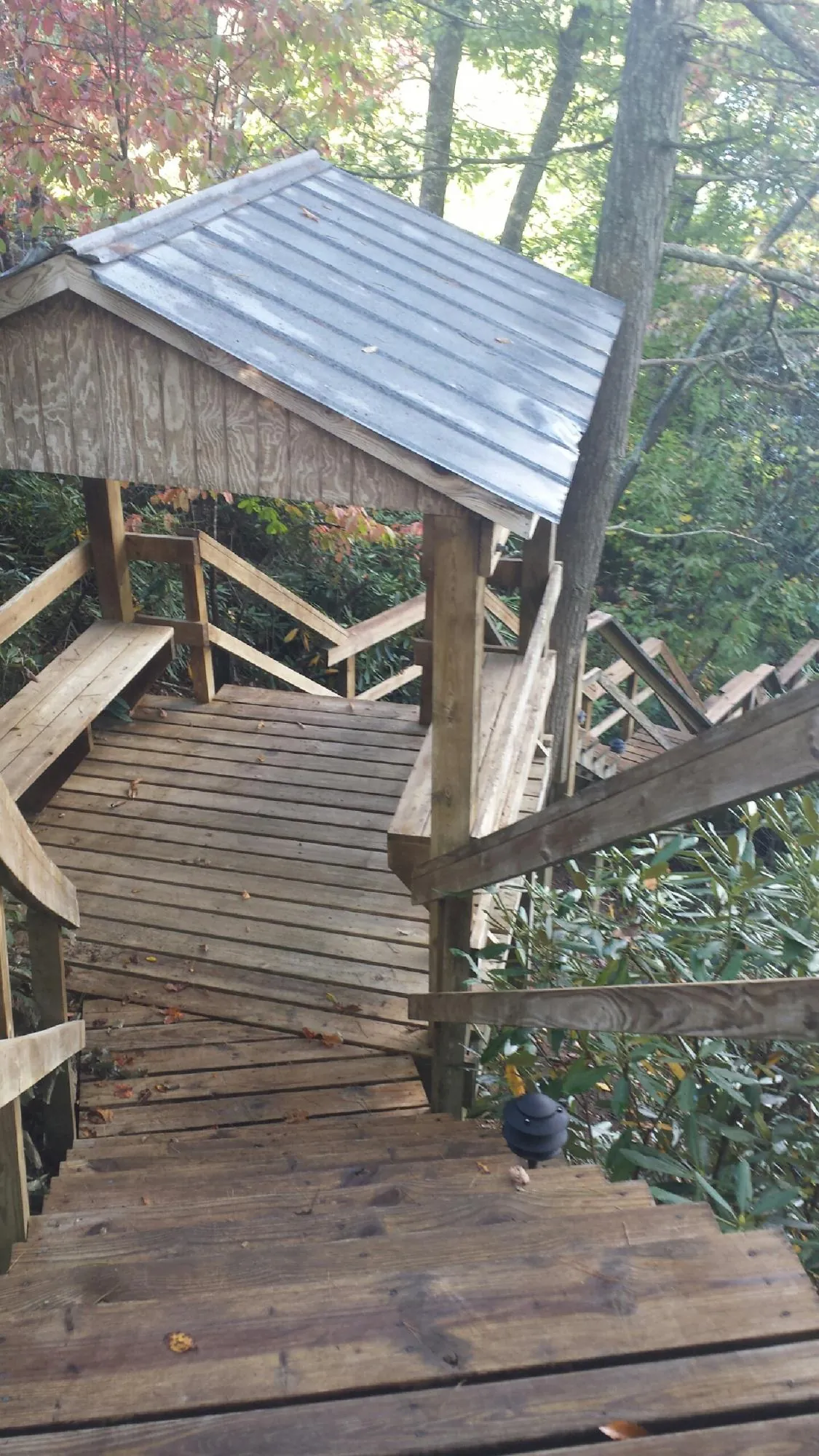 Metal roofed shelter over wooden steps on a wooded walkway — Skylight Repair & Installation work by our crew in Buzzards Bay