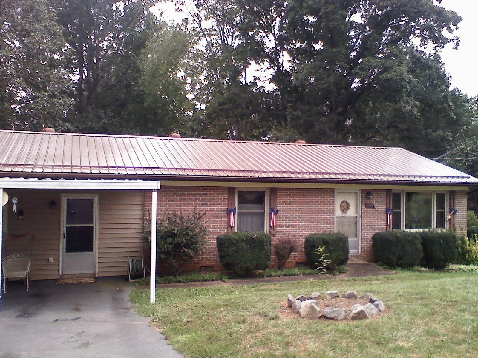 Bronze metal roof and carport on a brick ranch home — Roof Repair work by our crew in Buzzards Bay